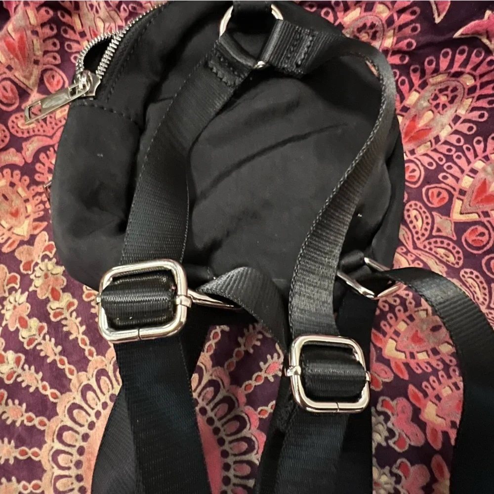 Dolls Kill • Logo Black Mini Backpack with silver exposed zipper, adjustable